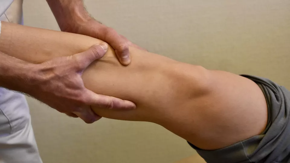 Händer som undersöker ett knä